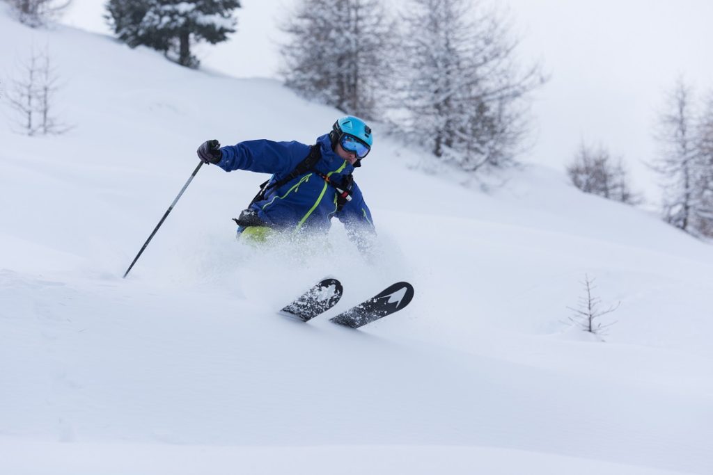 freeride skier skiing in deep powder snow